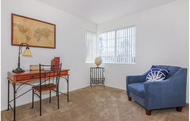 a living room with a blue chair and a desk at Riverview Springs, Oceanside, CA