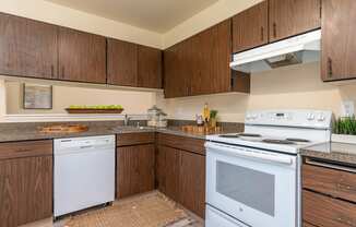 Model Kitchen with wood cabinetry and white appliances