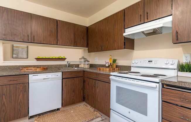 Model Kitchen with wood cabinetry and white appliances