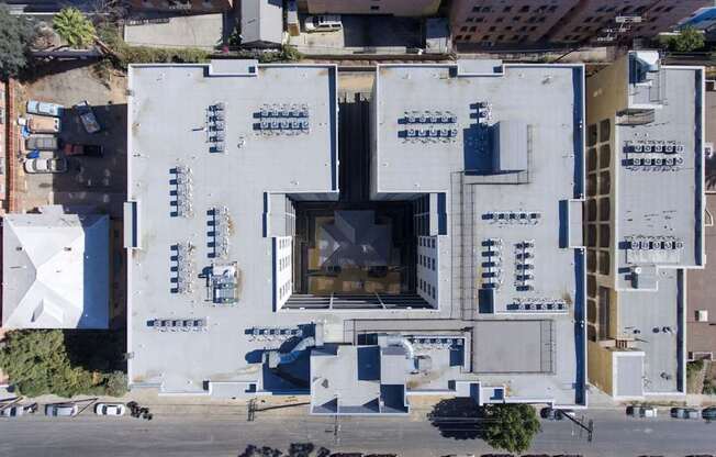 A large white building with a lot of windows and a parking lot in front.