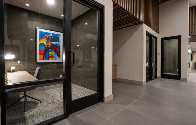 A modern office lobby with a glass door and a framed picture on the wall.