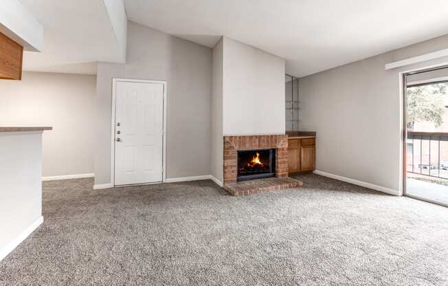 an empty living room with a fireplace and a window