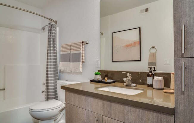 A bathroom with a toilet, sink, and shower.