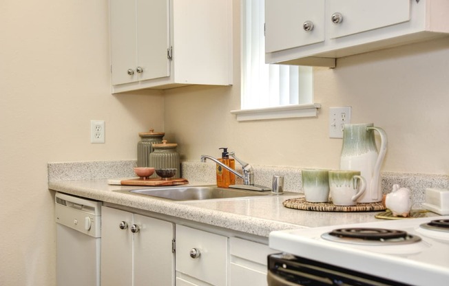 a kitchen with white cabinets and white appliances at Renaissance Park Apartments, Davis, CA, 95618