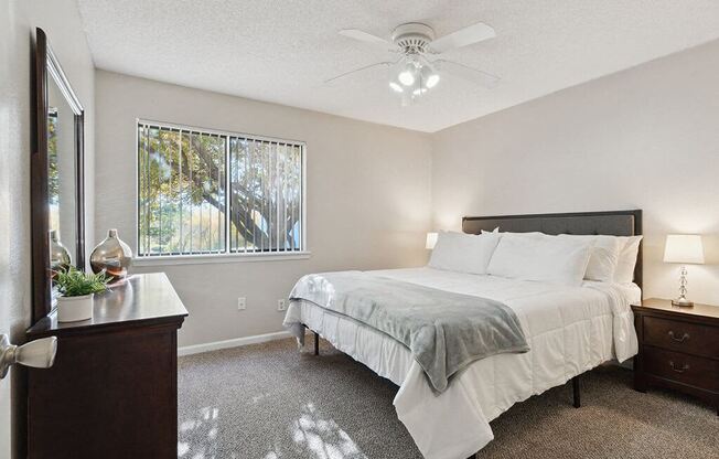 a bedroom with a bed and a ceiling fan