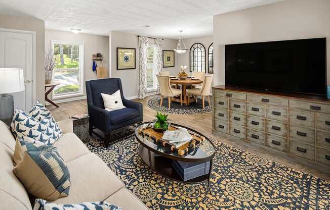 A living room with a blue chair and a patterned rug.