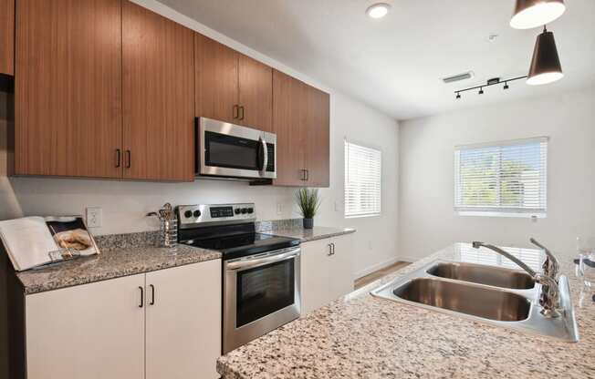 a modern kitchen with granite counter tops and stainless steel appliances at Gibson Oaks, Lakeland, 33809