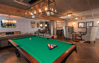 a pool table in a living room with a green pool