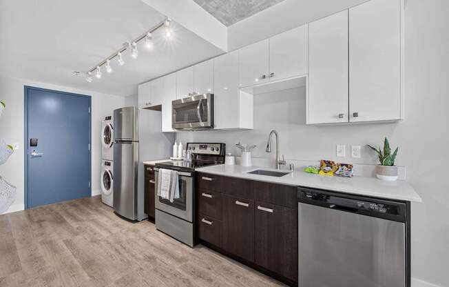 A modern kitchen with dark wood cabinets and stainless steel appliances.