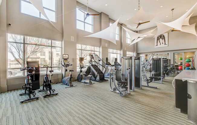 A gym with a variety of equipment including treadmills, stationary bikes, and weight machines.