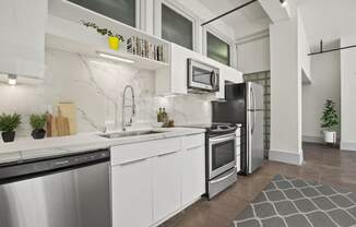 a kitchen with white cabinets and stainless steel appliances