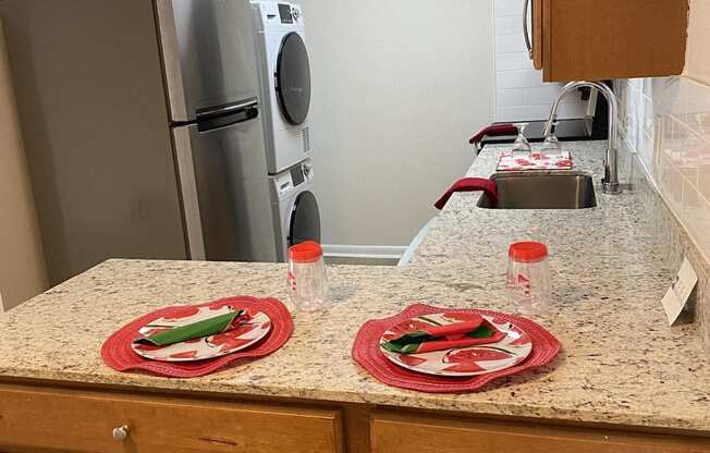 a kitchen with a counter with two plates on it and a refrigerator