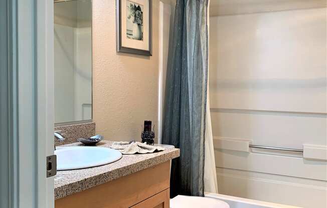 2 bedroom model guest bathroom in hallway 
toilet, shower/bath tub, sink with granite/ quartz counter top