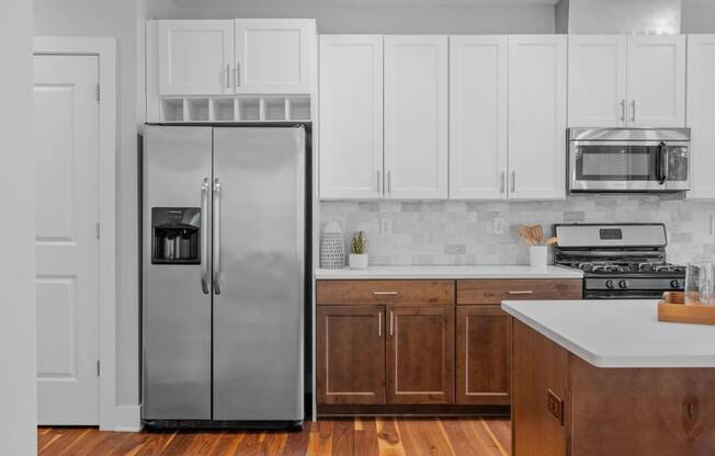 a kitchen with white cabinets and a stainless steel refrigerator