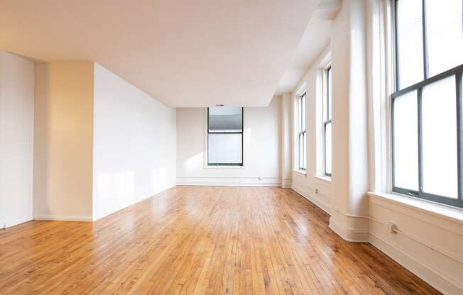 an empty room with hardwood floors and large windows at 26 West, Managed by Buckingham Urban Living, Indianapolis