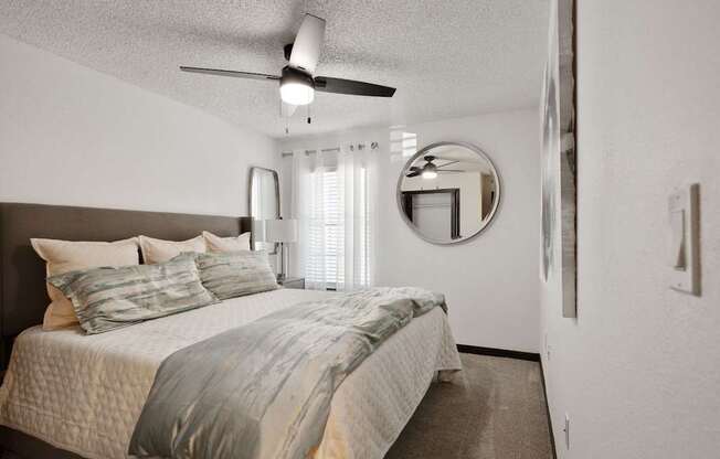 a bedroom with a bed and a ceiling fan at The Lorient Apartments, Pensacola, Florida