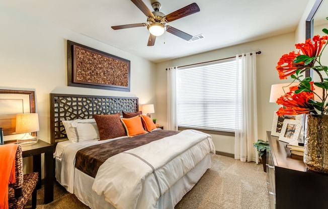 a bedroom with a large bed and a ceiling fan