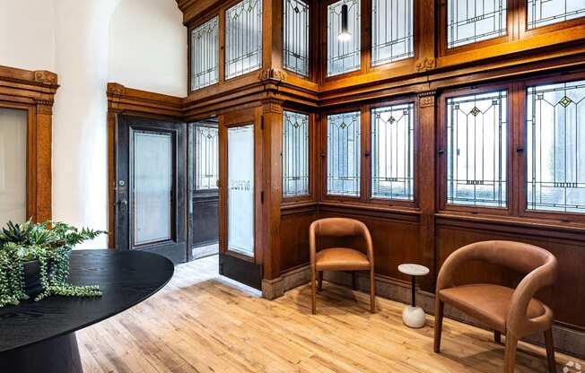 the lobby of a building with chairs and a table