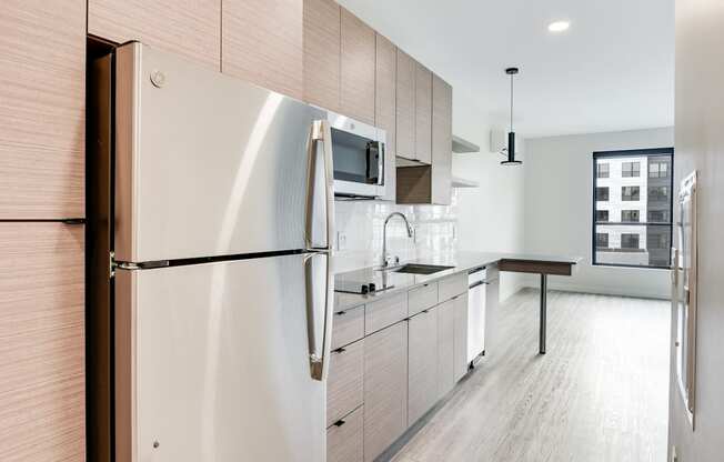 A modern kitchen with a stainless steel refrigerator and wooden cabinets.