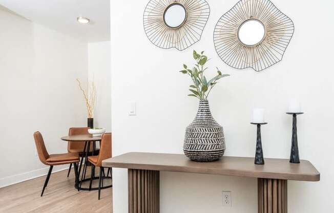 A dining room with a table, chairs, and decorative items.