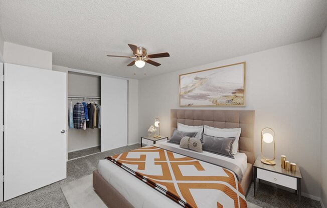 A bedroom with a bed, a ceiling fan, and a painting on the wall.