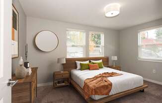 A bedroom with a bed, nightstands, and a round mirror on the wall.