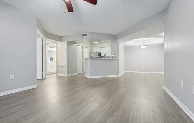 the living room and kitchen of an empty house with wood floors and a ceiling fan at Pembroke Pines Landings, Florida, 33025