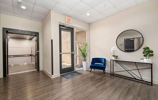 a room with a blue chair and a mirror in it