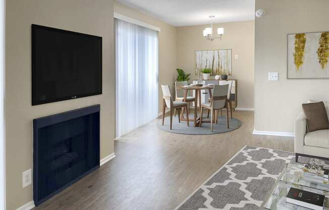 a living room with a fireplace and a dining room table with chairs