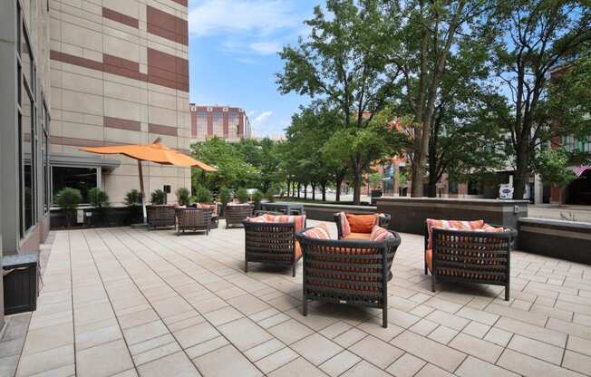 a patio with chairs and umbrellas in a courtyard