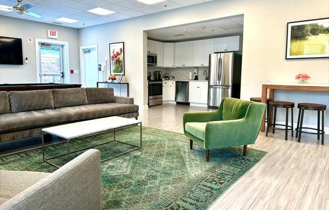 a living room with couches chairs and a kitchen in the background