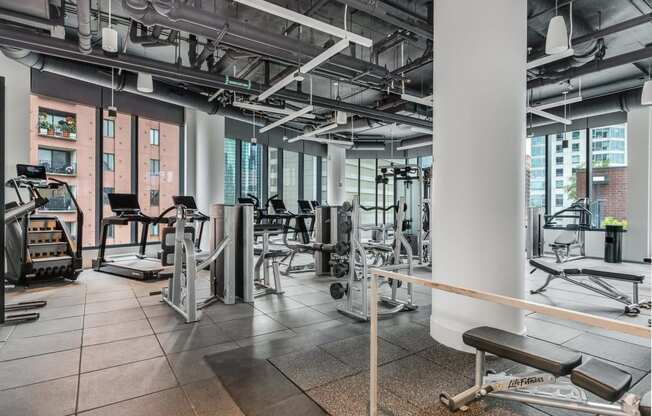 a gym with weights and cardio equipment in a building with tall windows  at Cassidy on Canal, Chicago, 60606