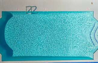A rectangular pool with a blue tinted water.