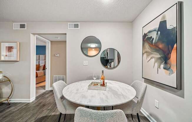 A modern dining room with a white table and chairs.