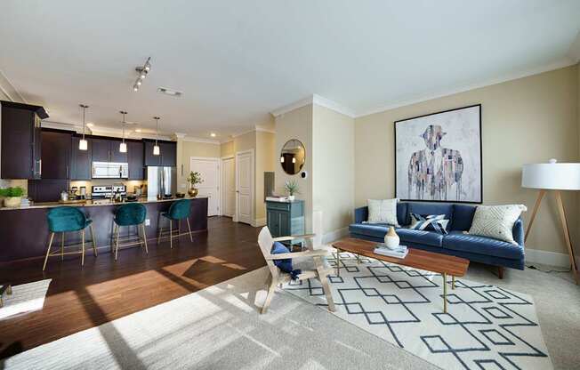 A living room with a blue couch and a rug with a geometric pattern.