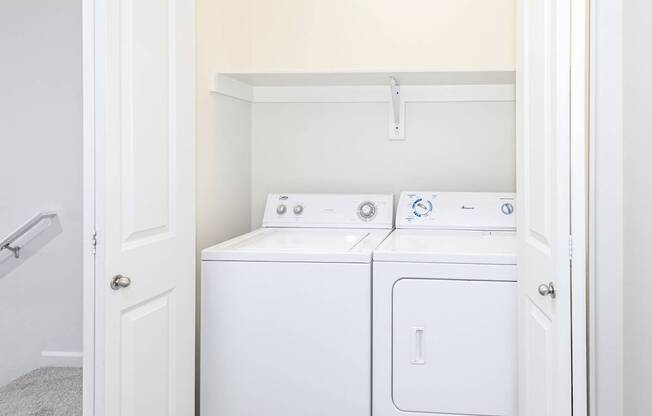A white washing machine and dryer in a laundry room at The Landing Apartments and Townhomes, Oregon, 97045