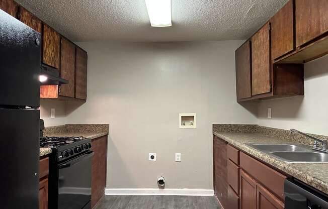 a kitchen with wooden cabinets and a stove and a sink