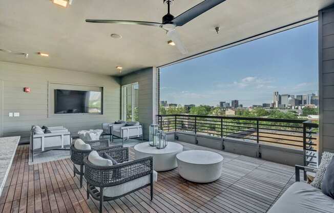 A patio with a ceiling fan and a view of the city.