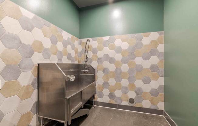 A stainless steel sink in a bathroom with hexagonal tiles.