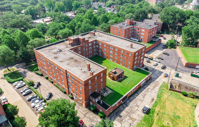 A large red brick building with a green lawn in front.