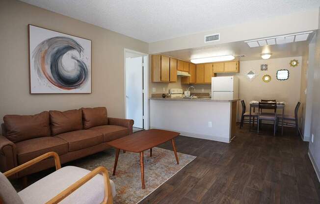 A living room with a brown couch and a painting on the wall.