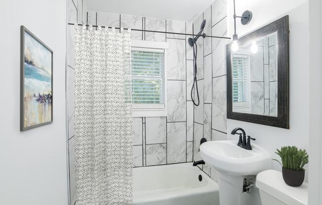 a white bathroom with a shower and a sink at Ann Street Lofts, Alabama, 36604