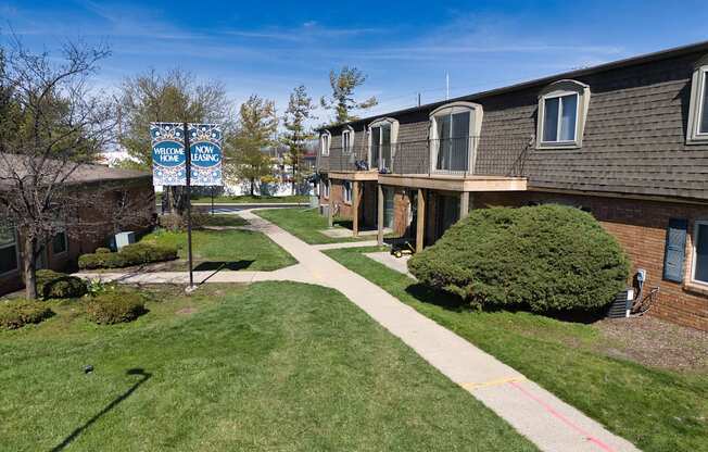 an apartment building with a sidewalk and a blue street sign