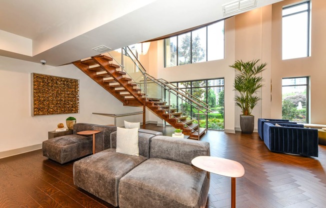 A living room with a grey couch and a staircase.