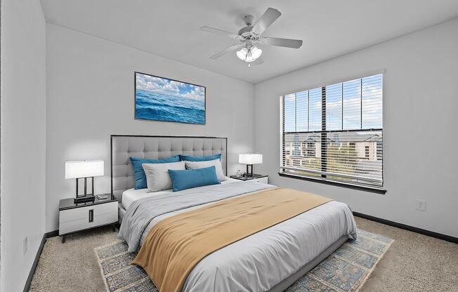 A bedroom with a large bed and a ceiling fan.