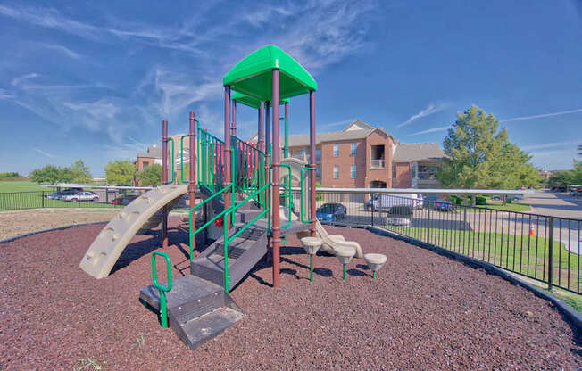 A playground with a green roof and a slide.
