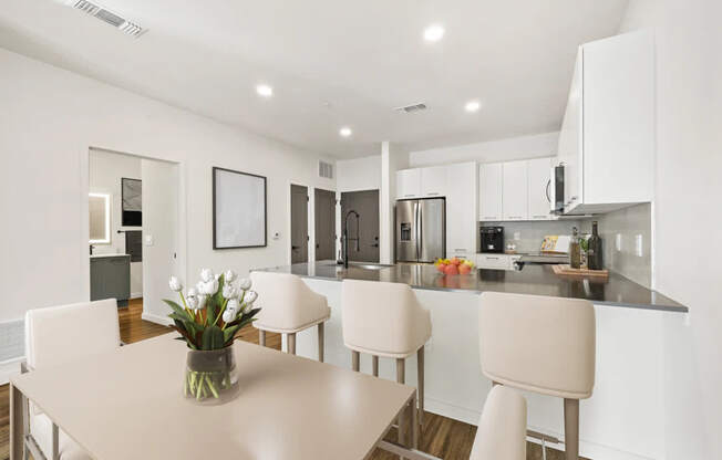 A modern kitchen with a dining table and chairs.