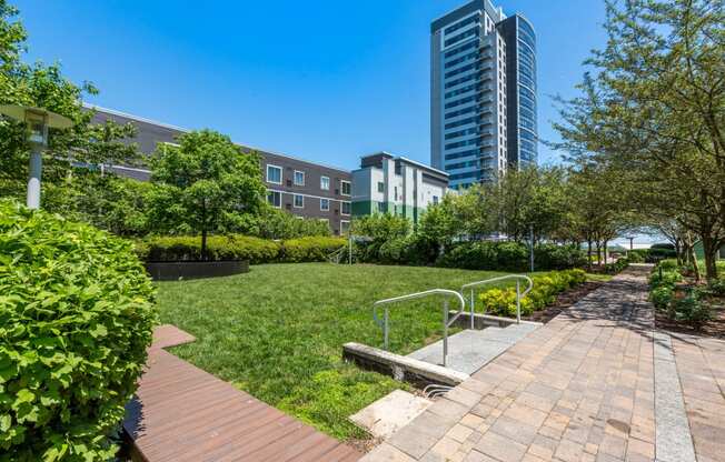 a park with a path and trees and buildings in the background