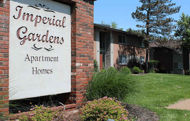 an apartment building with a sign that reads imperial gardens apartment homes