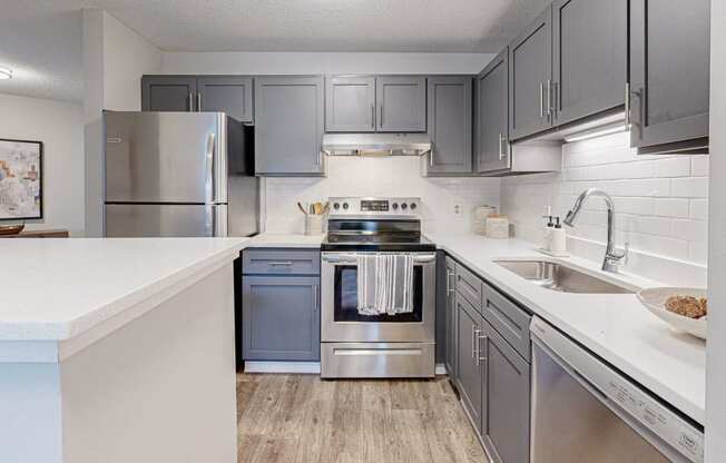 an updated kitchen with stainless steel appliances and white countertops